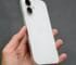 A person holding a white iPhone in their hand